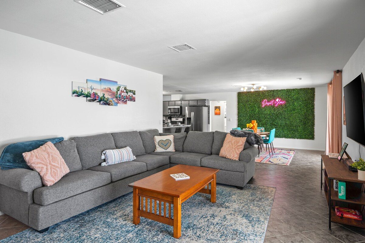 Living room sectional looking through to the kitchen and neon sign