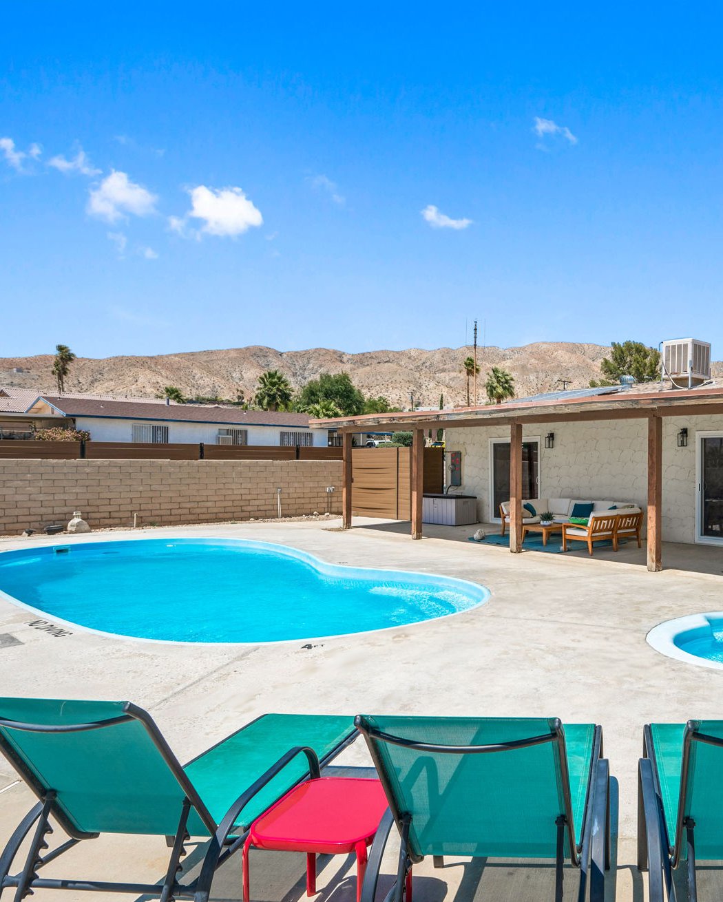 The private pool and desert mountains under an open blue sky